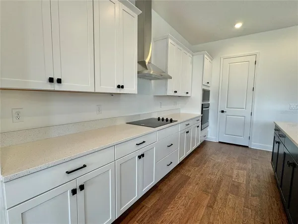a kitchen with granite countertop white cabinets and white appliances