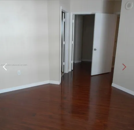an empty room with wooden floor and door