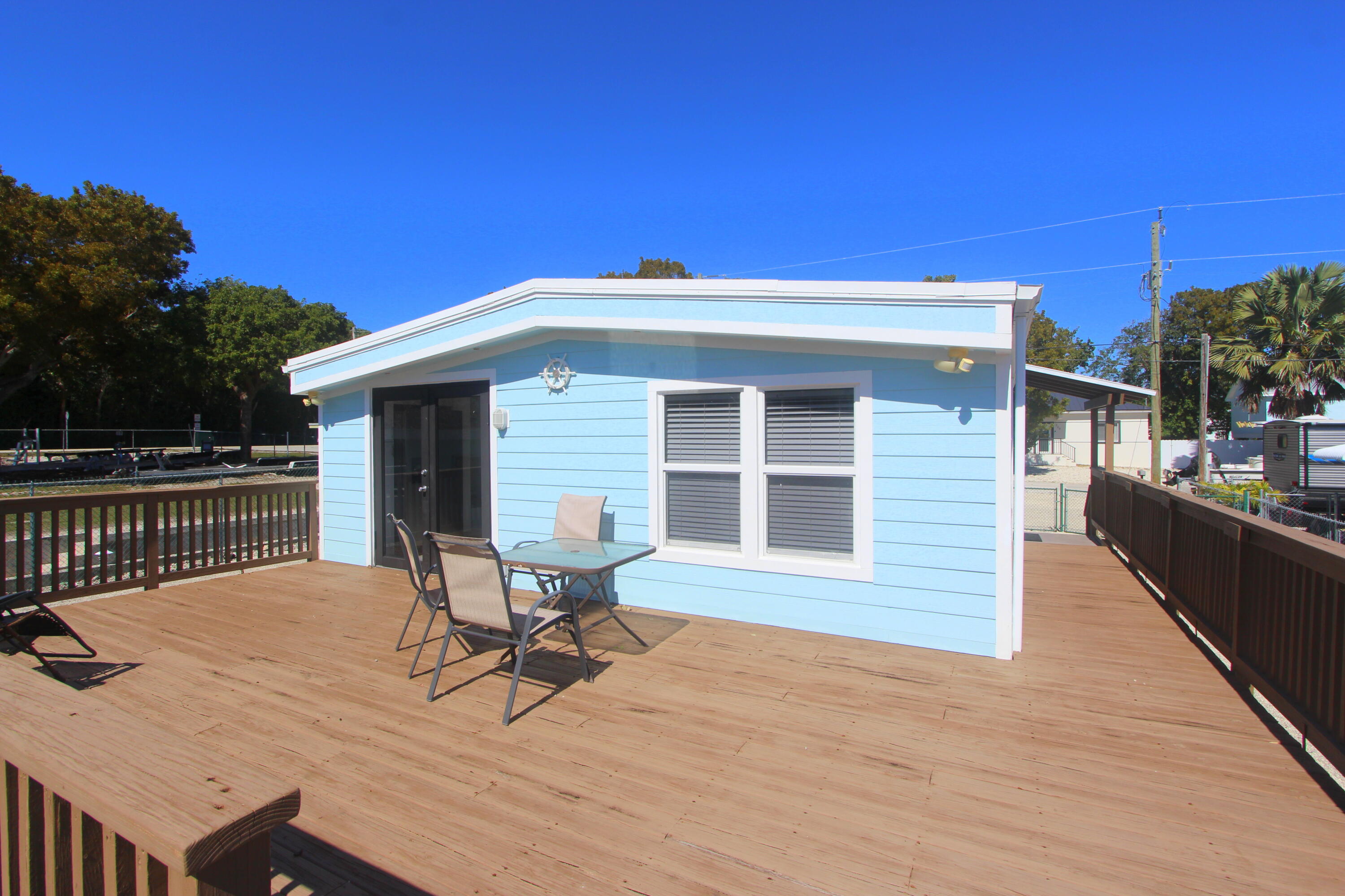 211 Lance Lane Key Largo, FL 33037 - Photo 34 of 52 a roof deck with table and chairs and wooden floor