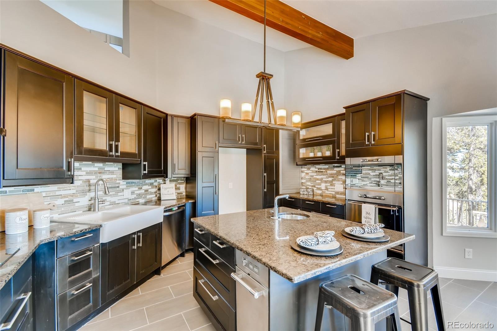 27732 Squaw Pass Road Evergreen, CO 80439 - Photo 11 of 38 a kitchen with kitchen island granite countertop lots of counter top space and stainless steel appliances