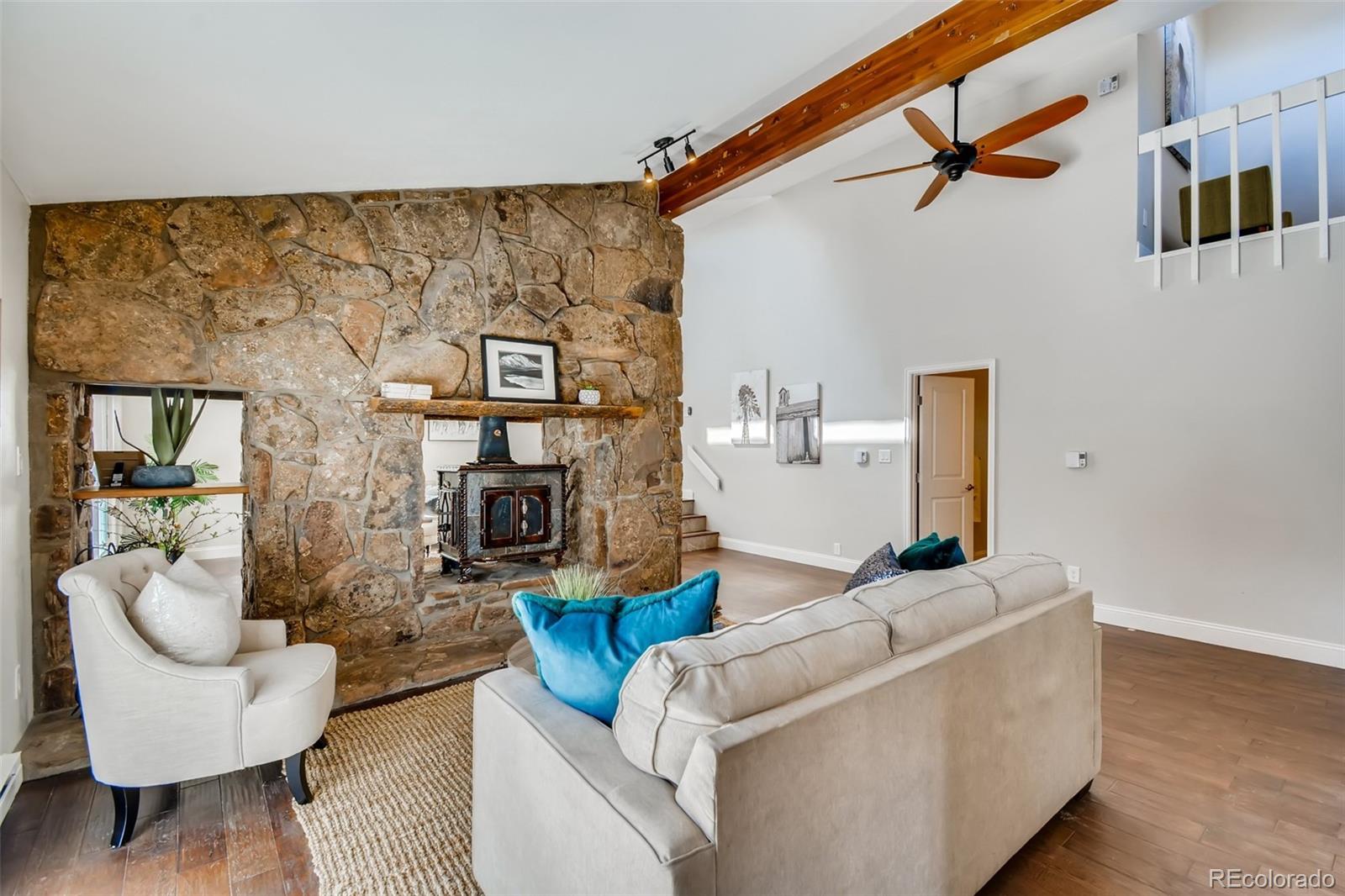 27732 Squaw Pass Road Evergreen, CO 80439 - Photo 16 of 38 a living room with furniture and a fireplace