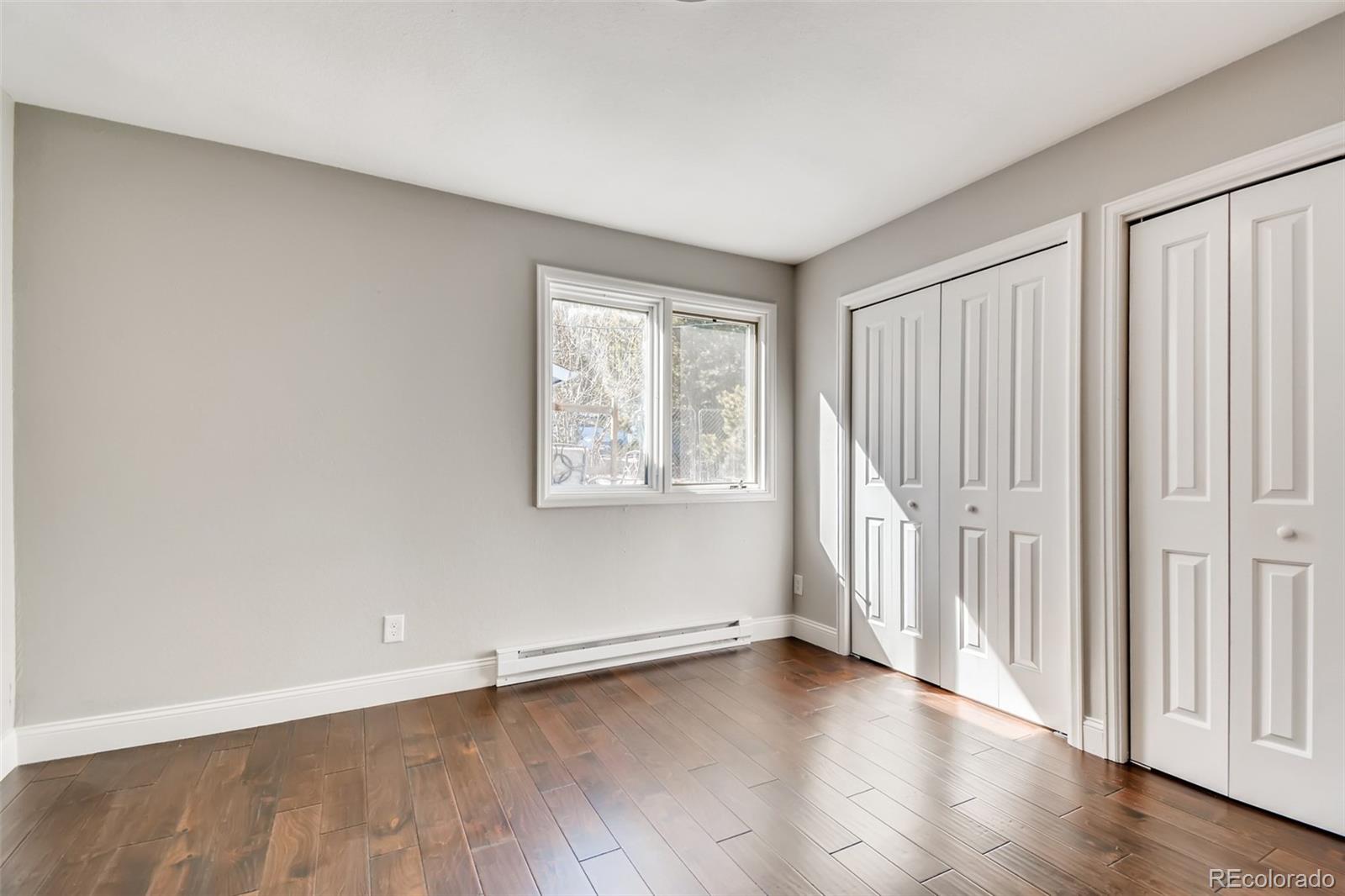27732 Squaw Pass Road Evergreen, CO 80439 - Photo 19 of 38 an empty room with wooden floor and windows