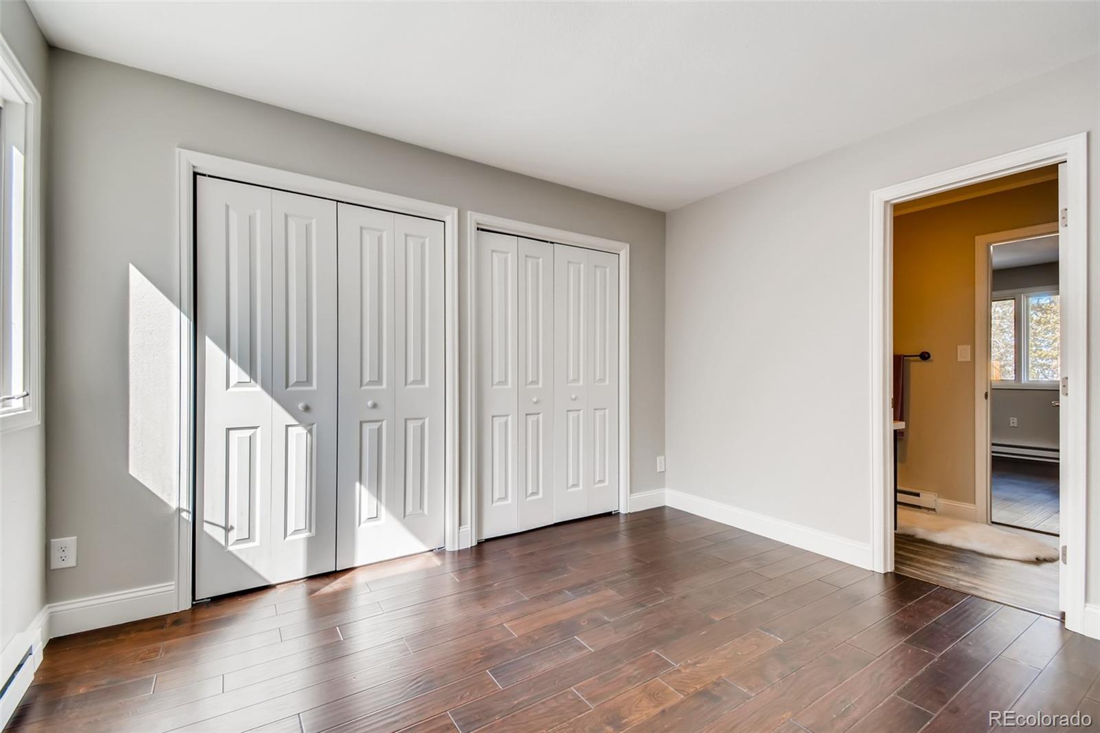 27732 Squaw Pass Road Evergreen, CO 80439 - Photo 20 of 38 a view of an empty room with wooden floor and a window