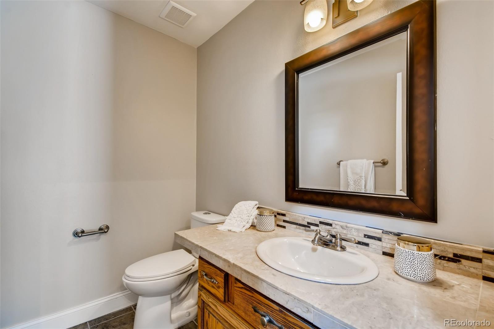 27732 Squaw Pass Road Evergreen, CO 80439 - Photo 21 of 38 a bathroom with a granite countertop sink mirror and toilet