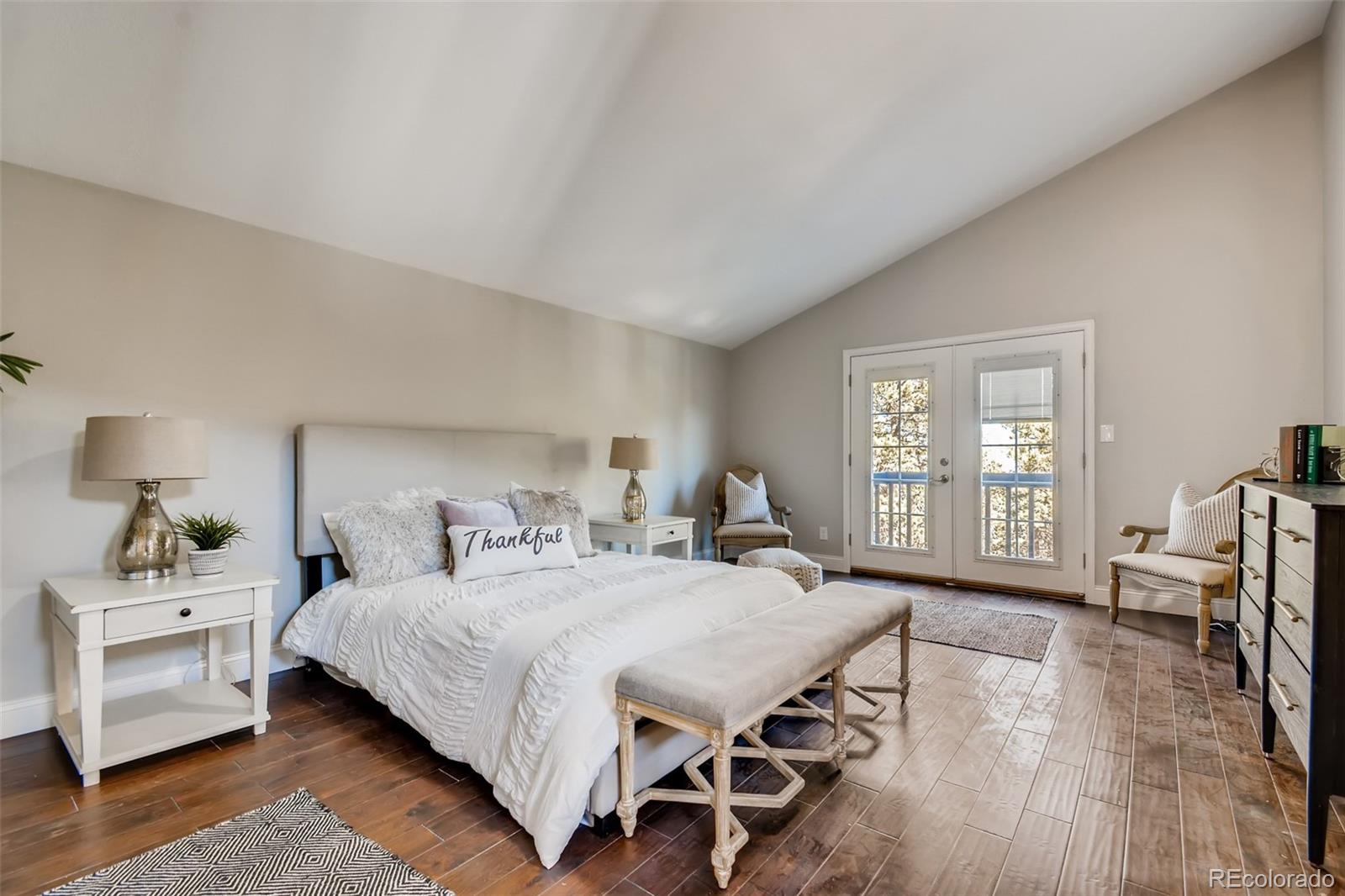 27732 Squaw Pass Road Evergreen, CO 80439 - Photo 22 of 38 a bedroom with a bed and wooden floor