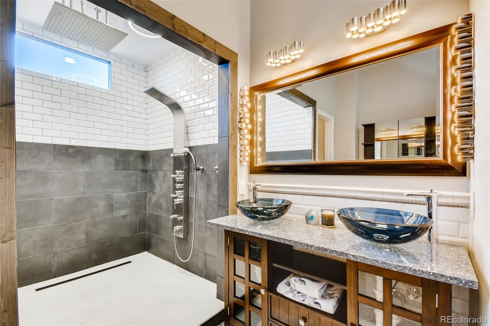 27732 Squaw Pass Road Evergreen, CO 80439 - Photo 24 of 38 a bathroom with a sink a mirror and a shower