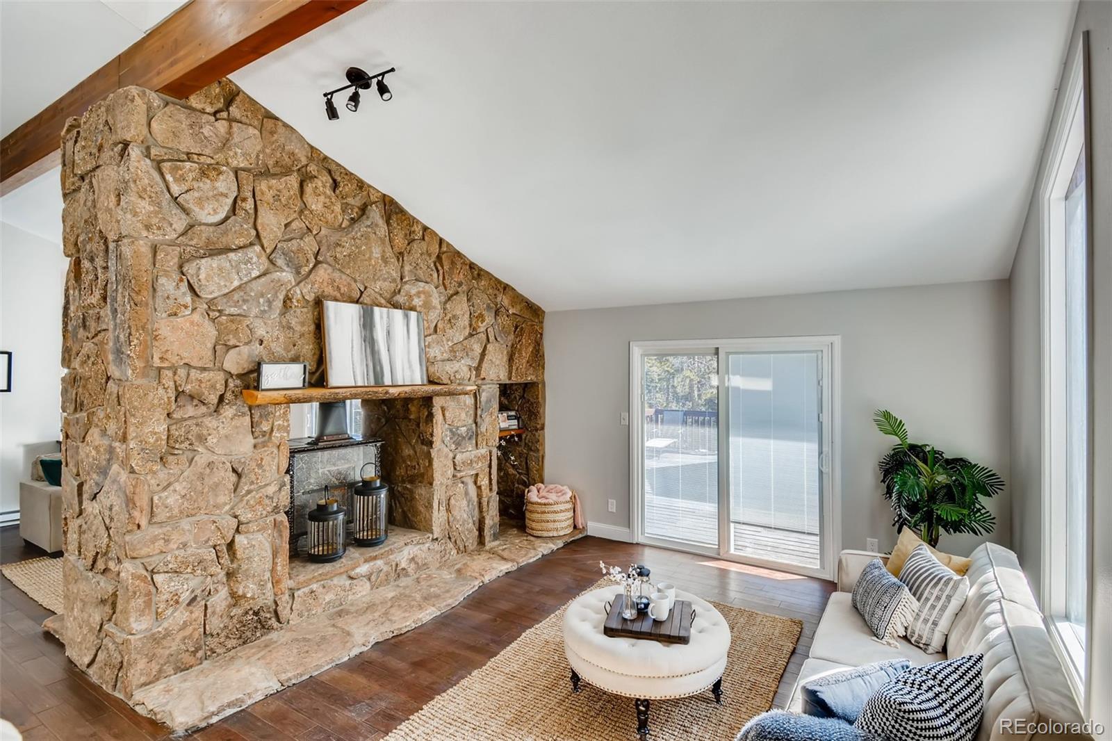 27732 Squaw Pass Road Evergreen, CO 80439 - Photo 5 of 38 a living room with furniture and a floor to ceiling window
