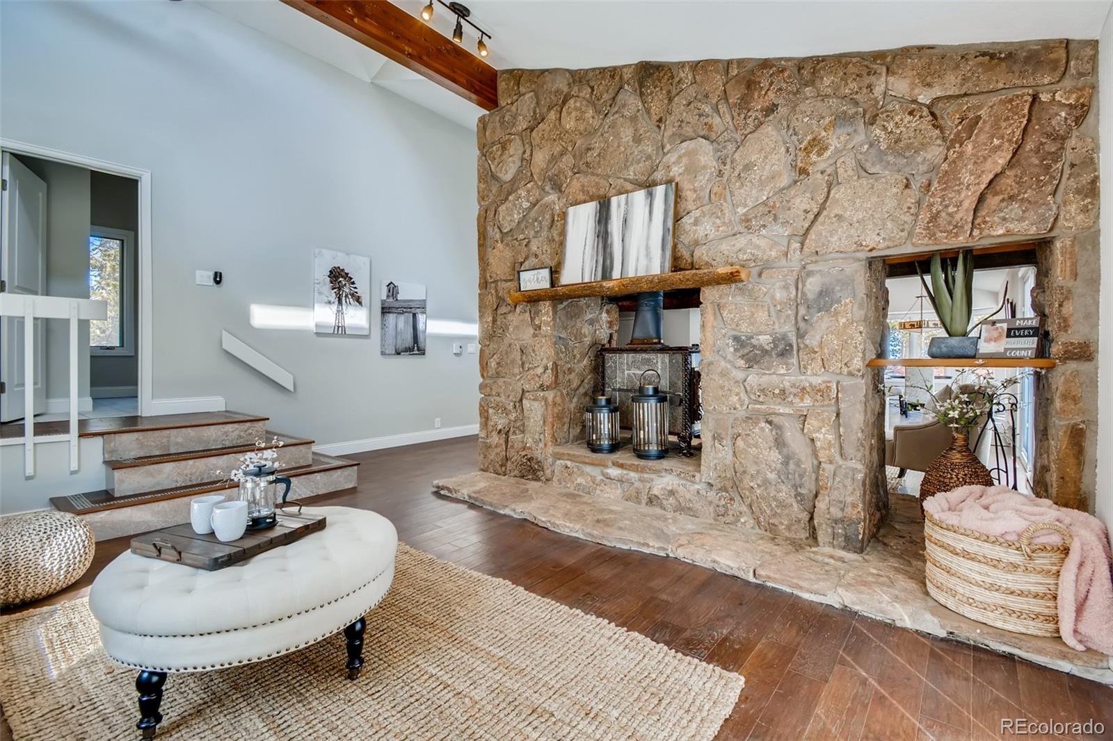 27732 Squaw Pass Road Evergreen, CO 80439 - Photo 7 of 38 a living room with furniture and a fireplace
