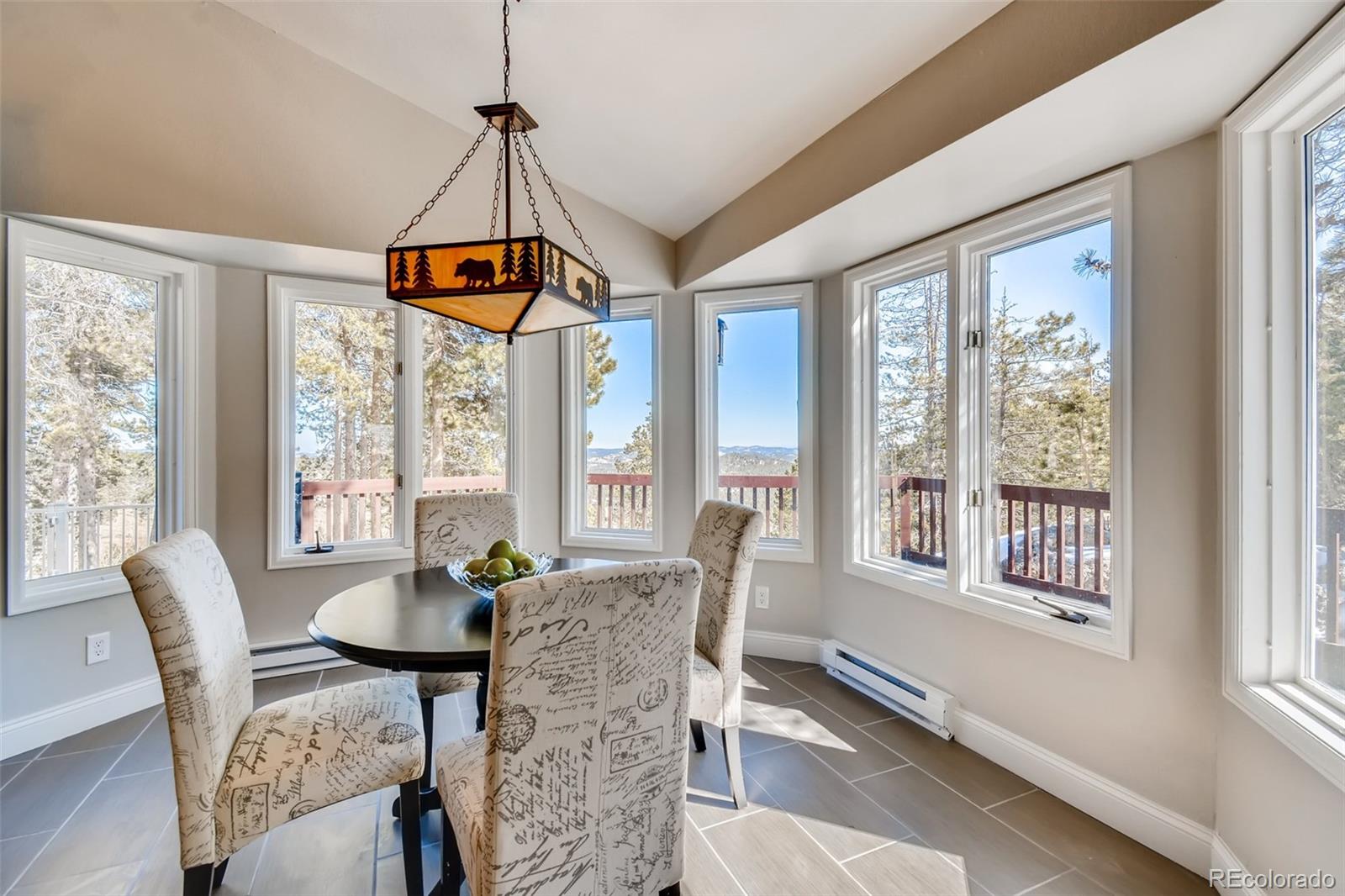 27732 Squaw Pass Road Evergreen, CO 80439 - Photo 8 of 38 a dining room with furniture a chandelier and wooden floor