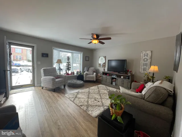 a living room with furniture a flat screen tv and a window