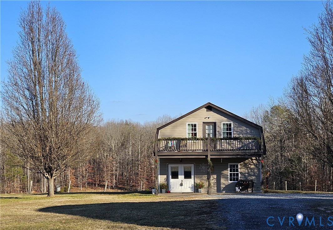 a front view of a house with a yard and lake view