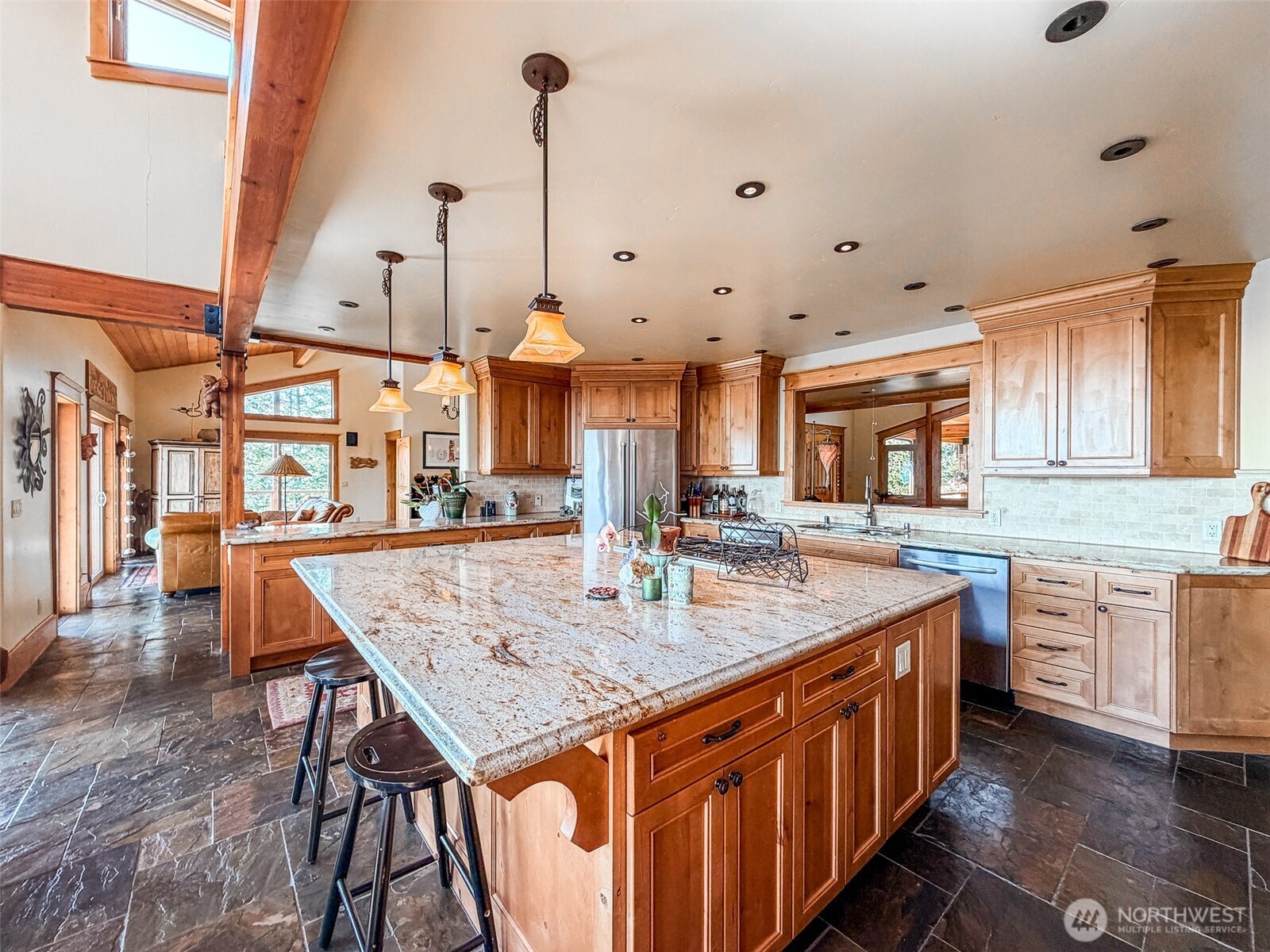 726 Pine Ridge Drive Orcas Island, WA 98280 - Photo 8 of 40 a kitchen with stainless steel appliances kitchen island granite countertop a table chairs in it and wooden floors