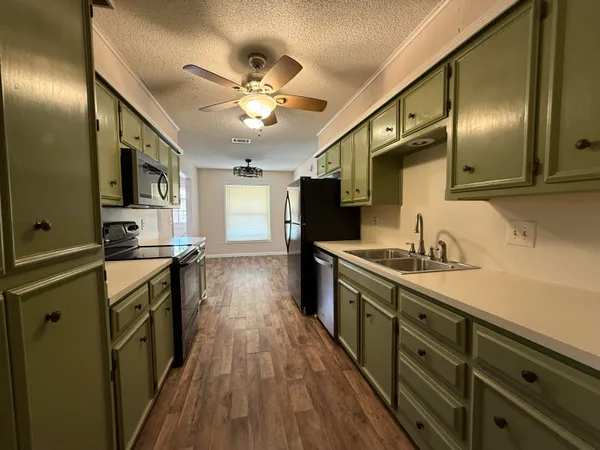 a kitchen with granite countertop a sink appliances cabinets and furniture