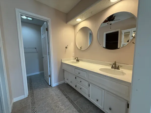 a spacious bathroom with a double vanity sink and a mirror