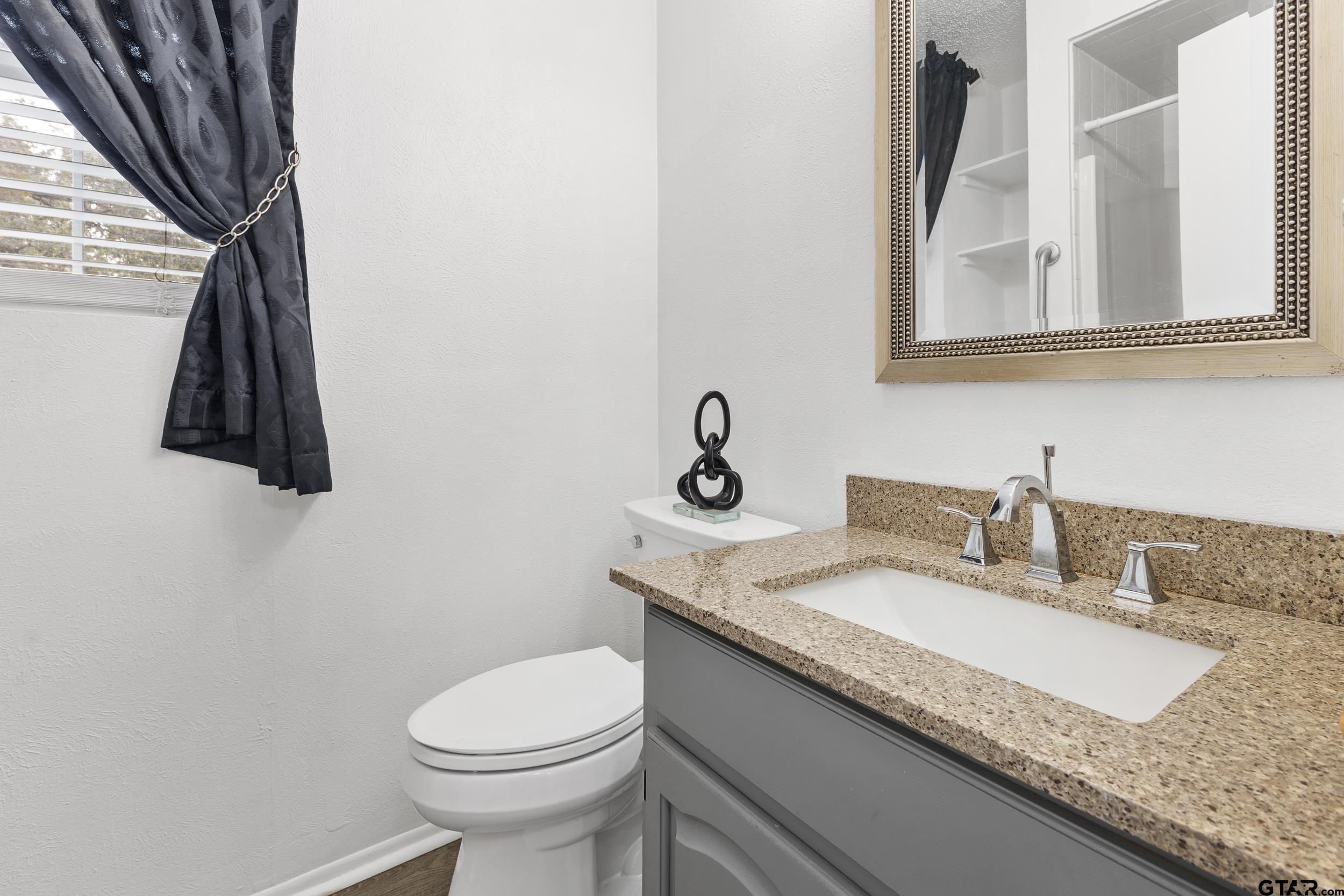 109 King Lyle Road Scroggins, TX 75480 - Photo 24 of 46 a bathroom with a granite countertop sink and a toilet