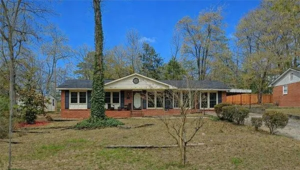 a front view of a house with large trees