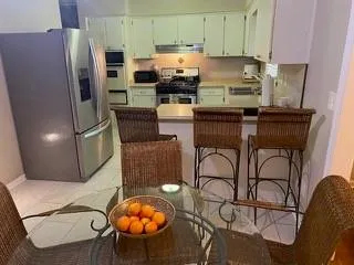 a kitchen with stainless steel appliances granite countertop a refrigerator a stove a sink and a microwave