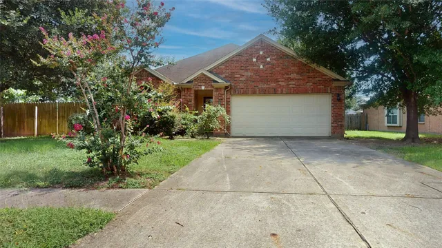 a front view of a house with a garden and trees