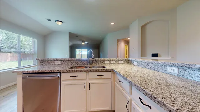 a bathroom with a granite countertop double vanity sink and mirror
