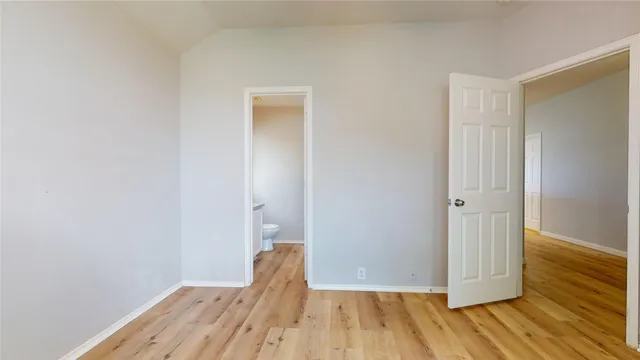 a view of a room with wooden floor and a hallway