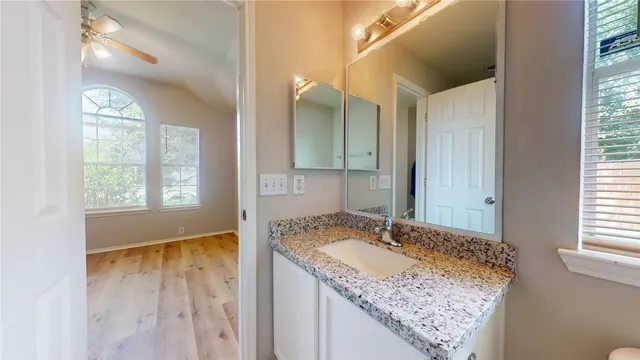 a bathroom with a granite countertop sink and a mirror