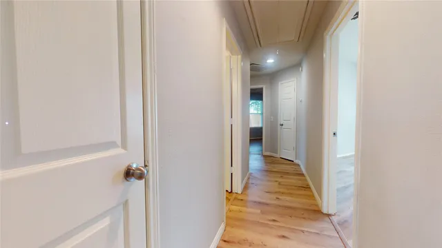a view of a hallway with wooden floor