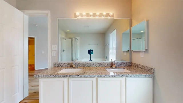 a bathroom with a granite countertop sink and a mirror