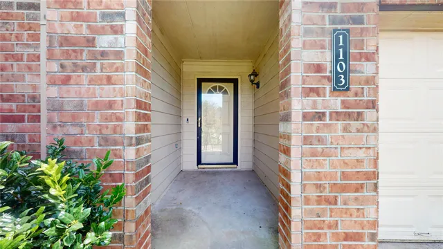 a view of a bathroom with a shower and a plant