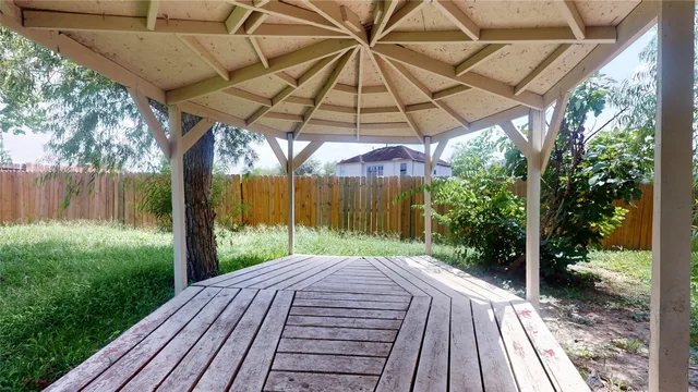 a view of a backyard with table and chairs under an umbrella
