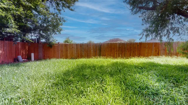 a view of swimming pool with a yard and wooden fence