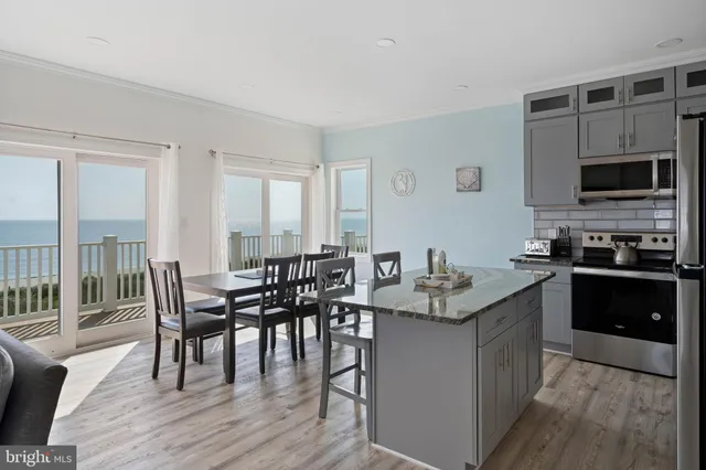 a kitchen with granite countertop kitchen island wooden floor and stainless steel appliances
