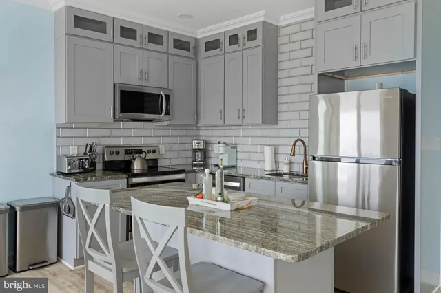 a kitchen with appliances a sink and cabinets