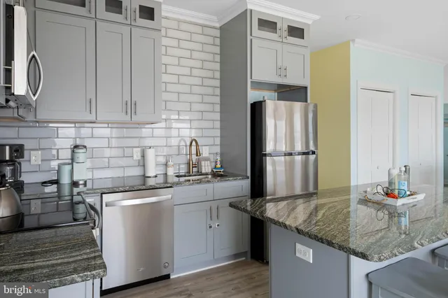 a kitchen with stainless steel appliances granite countertop a sink a refrigerator and a stove