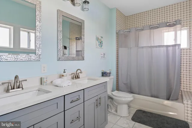 a bathroom with a toilet a sink a mirror a shower and vanity