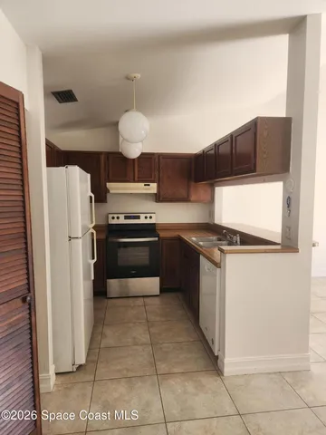 a kitchen with stainless steel appliances granite countertop a stove a refrigerator and a sink