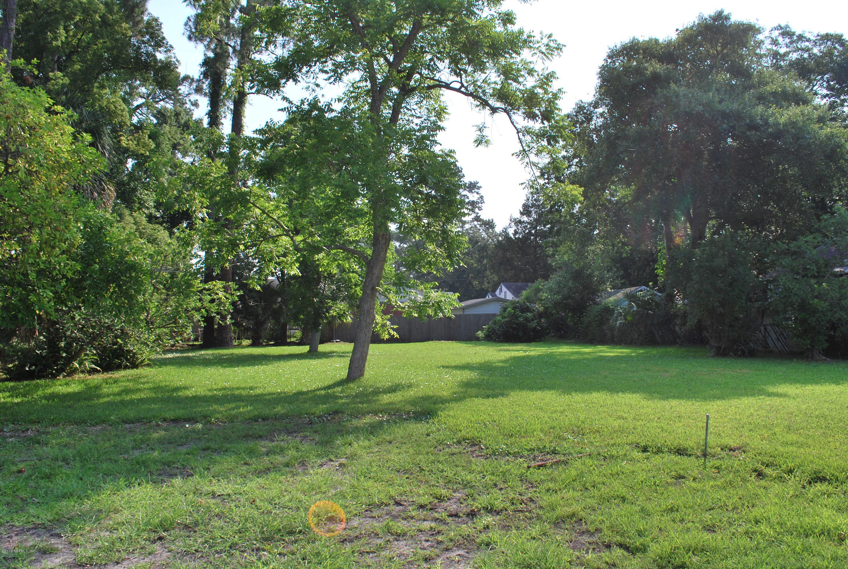 a view of a grassy field with trees