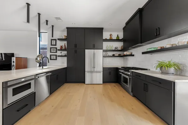 a kitchen with stainless steel appliances a sink stove and refrigerator