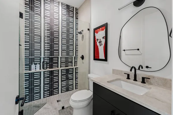 a bathroom with a toilet sink vanity and mirror