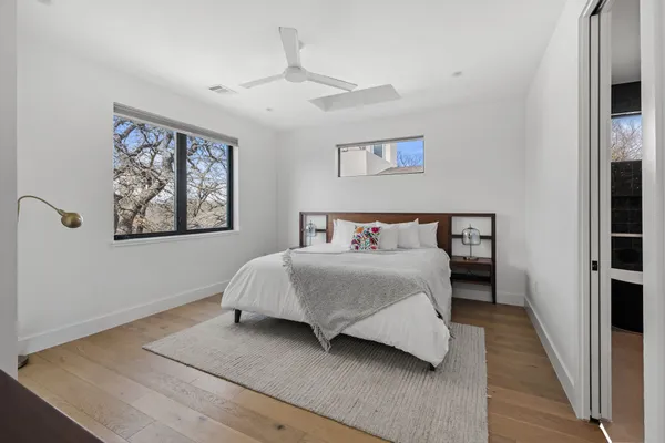 a bedroom with a large bed and a chandelier
