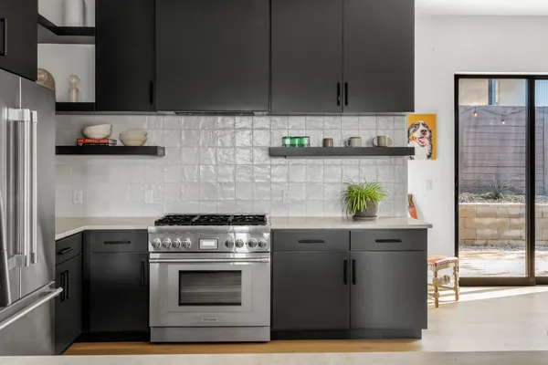 a kitchen with stainless steel appliances granite countertop a stove a sink and a refrigerator