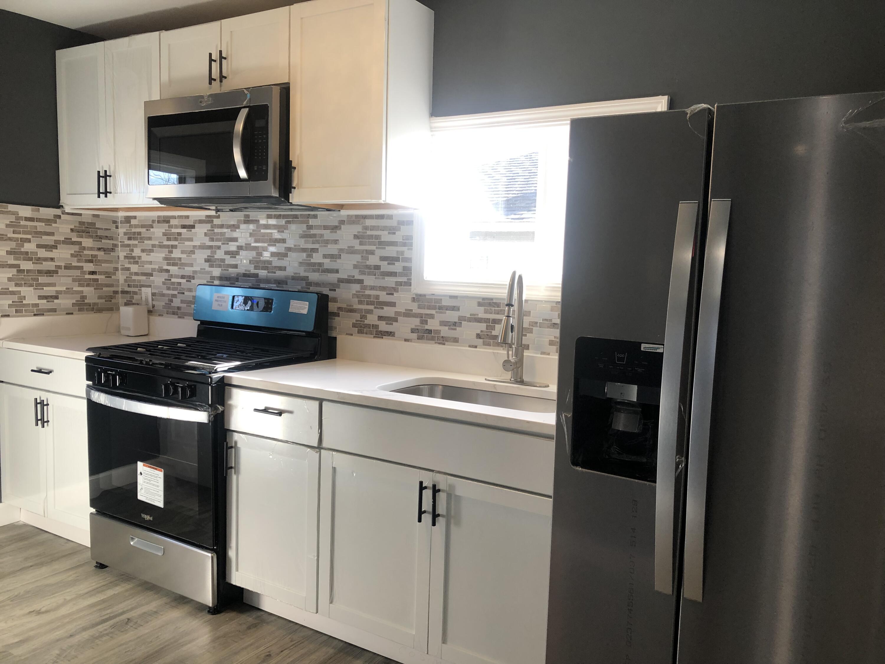 1967 Cleveland Street Gary, IN 46404 - Photo 13 of 38 a kitchen with stainless steel appliances granite countertop a refrigerator and a sink