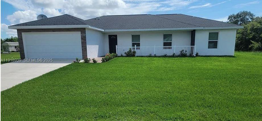 417 Cherry Tree Drive Sebring, FL 33876 - Photo 1 of 26 a front view of a house with a yard and garage