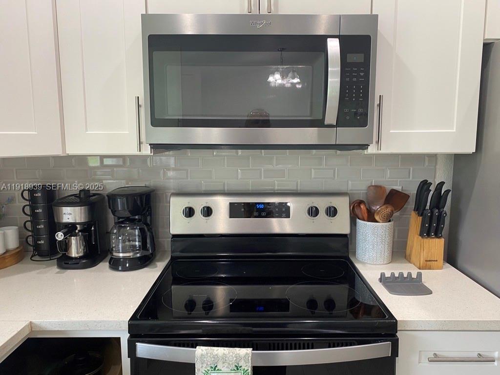 417 Cherry Tree Drive Sebring, FL 33876 - Photo 13 of 26 a kitchen with a stove and a microwave