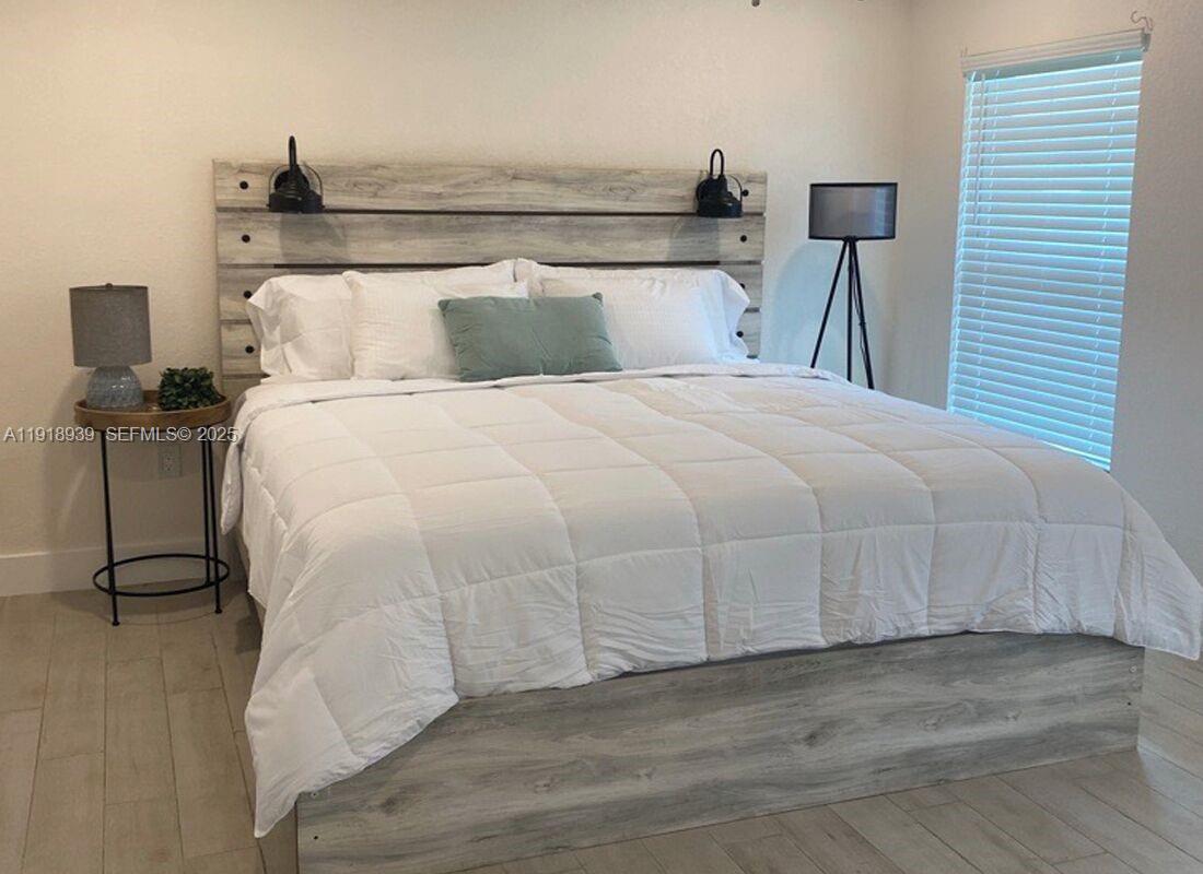 417 Cherry Tree Drive Sebring, FL 33876 - Photo 16 of 26 a bedroom with a bed and wooden floor