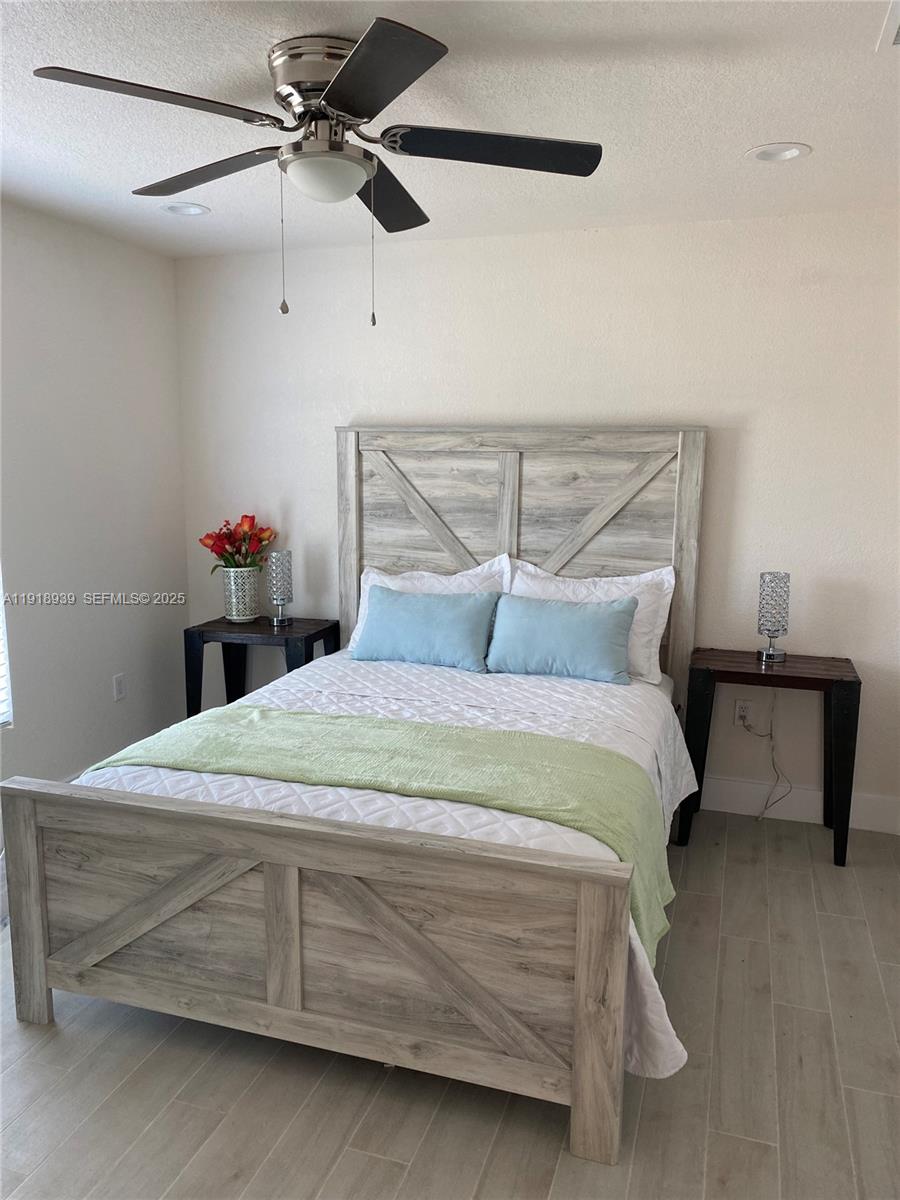 417 Cherry Tree Drive Sebring, FL 33876 - Photo 19 of 26 a bedroom with a bed and a chandelier