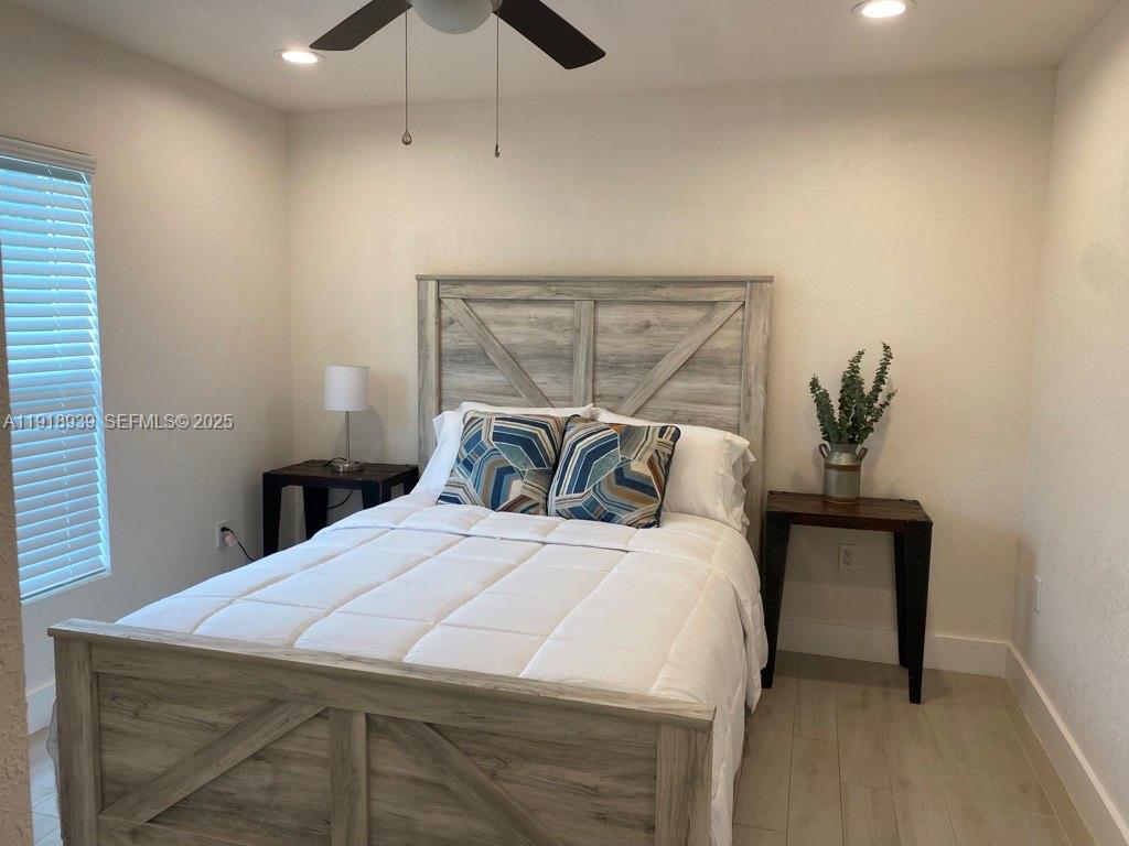 417 Cherry Tree Drive Sebring, FL 33876 - Photo 21 of 26 a bedroom with a bed and ceiling fan