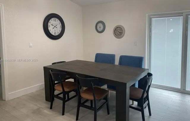 a view of a dining area with furniture and wall clock