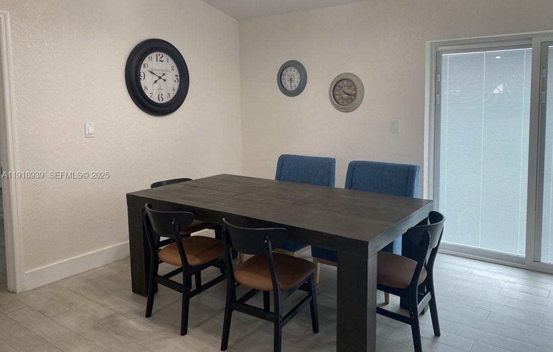 417 Cherry Tree Drive Sebring, FL 33876 - Photo 7 of 26 a view of a dining area with furniture and wall clock