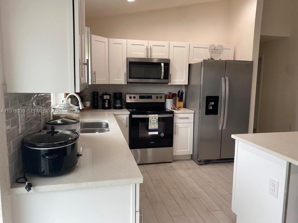 417 Cherry Tree Drive Sebring, FL 33876 - Photo 9 of 26 a kitchen with a sink stainless steel appliances and cabinets
