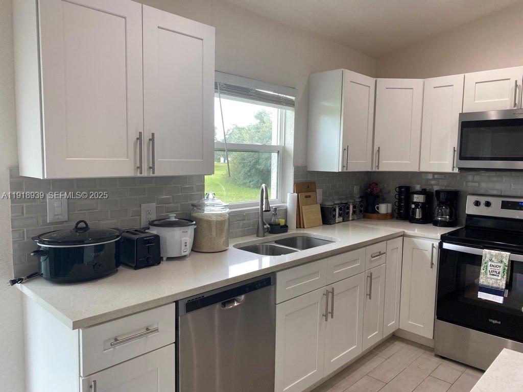 417 Cherry Tree Drive Sebring, FL 33876 - Photo 10 of 26 a kitchen with a sink a stove and cabinets